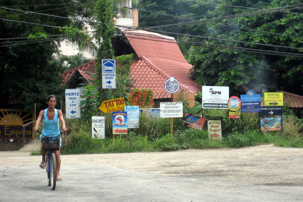 Costa Rica Travel Guide 201 Signs at Tamarindo Beach, Costa Rica with girl on bike