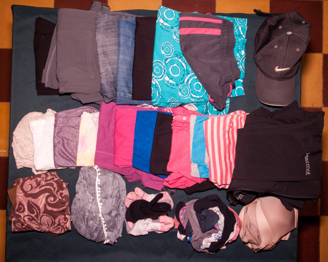 Packing list for a girl's clothes all laid out on table