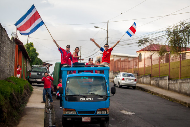Costa Ricans Waving Flags from a truck
