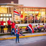 People waving flags in front of a restaurant