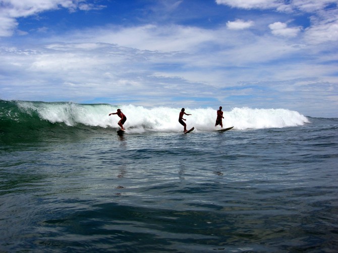 Surfers Riding a wave in Costa Rica at Manuel Antonio beach