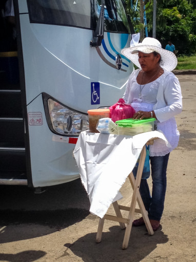 Lady selling food by bus