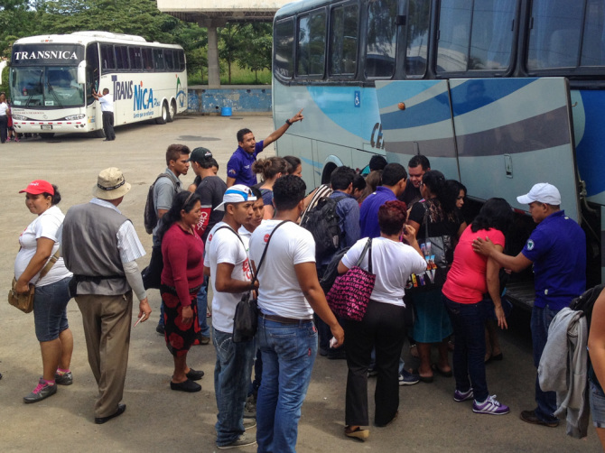 Unloading bags from a bus with a big crowd of people watching to avoid tourist scams